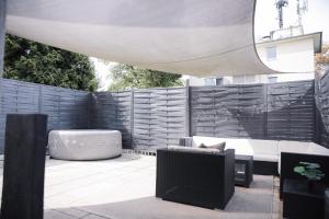 a patio with a couch and a table and chairs at Whirlpool - zentral - Designloft mit XXL Terrasse in Wiesbaden