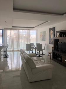 a living room with a couch and a table with chairs at Apartamento Deluxe Santa Filomena in Mindelo