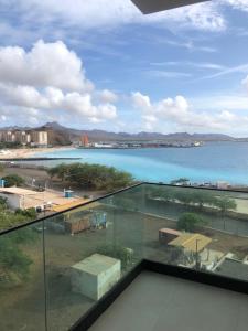 a view of the ocean from a glass balcony at Apartamento Sta. Filomena in Mindelo
