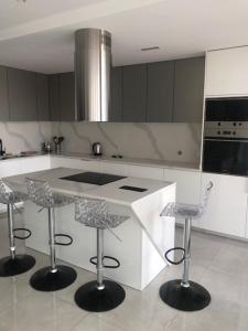 a kitchen with a counter and two bar stools at Apartamento Sta. Filomena in Mindelo