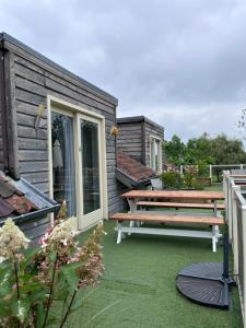 a patio with a bench and a picnic table at B&B Het Eycken Huys in Aalter