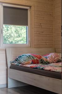 a bed in a room with a window at Domki Letniskowe Kraina Jodu in Bobolin