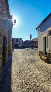 an empty street with a building and a clock tower at Casa da Praça in Freixo de Numão