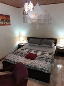 ein Schlafzimmer mit einem Bett mit zwei Lampen und einem Stuhl in der Unterkunft Sonke Ball House(Nyumba Yangati Mpira) in Nyambadwe