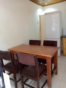 einen Holztisch mit Stühlen und ein Whiteboard in einem Zimmer in der Unterkunft Sonke Ball House(Nyumba Yangati Mpira) in Nyambadwe
