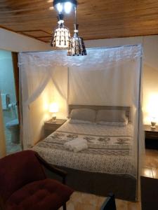 a bedroom with a canopy bed with two lights at Sonke Ball House(Nyumba Yangati Mpira) in Nyambadwe