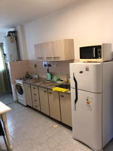 Una cocina con un refrigerador blanco y un microondas. en Dpto Bon Lee, en Puerto Madryn