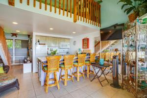 a kitchen with a bar with yellow stools at Oceanfront Maunaloa Condo, Steps to Pool and Beach! in Maunaloa