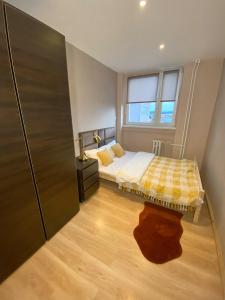 ein kleines Schlafzimmer mit einem Bett und einem Fenster in der Unterkunft Apartament Panorama Centrum in Legnica