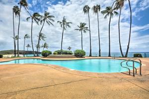 una piscina con palmeras frente al océano en Oceanfront Maunaloa Condo, Steps to Pool and Beach! en Maunaloa