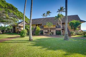 una casa con palmeras delante en Oceanfront Maunaloa Condo, Steps to Pool and Beach! en Maunaloa