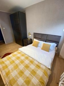 a bedroom with a large bed with a checkered blanket at Apartament Panorama Centrum in Legnica