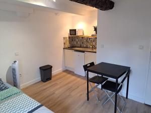 a small room with a table and a kitchen at BudgetBnb Studio centre ancien in Hyères