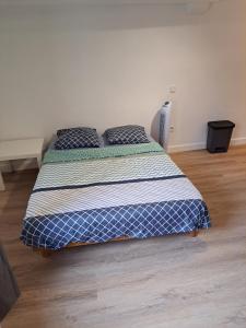 a bedroom with a bed with a blue and white comforter at BudgetBnb Studio centre ancien in Hyères