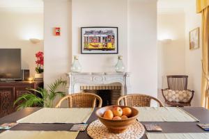 a dining room with a table with a bowl of fruit at Central Cascais Apartment with private parking in Cascais