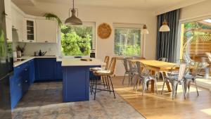 a kitchen with blue cabinets and a table and chairs at Jacuzzi, trasą S7 w 2h z Warszawy i Gdanska, Jadamowo holidaymazury nad jeziorem Mielno in Olsztynek