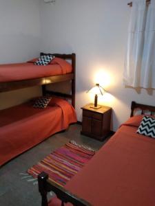 1 dormitorio con 2 literas y una lámpara en una mesa en EL BAGUAL DE MONTE en San Miguel del Monte