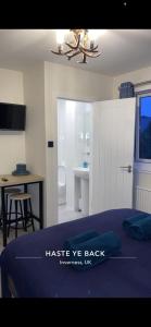 a bedroom with a bed and a table and a desk at Haste Ye Back in Inverness