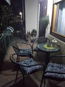 um pátio com 3 cadeiras, uma mesa e uma janela em Fina Apartment em Leskovac