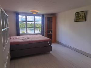 1 dormitorio con cama y ventana en Embracing nature's Swedish house, en Ludvika