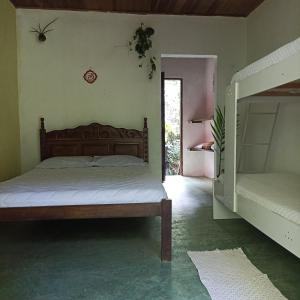een slaapkamer met een bed en een stapelbed bij Pousada Portal Floresta Paraty in Paraty