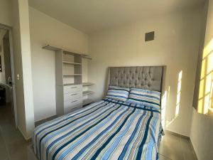 a bedroom with a bed with blue and white stripes at La Morada de Sofía in La Sabana