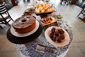 a table with a cake and a plate of food at Pousada Acqua Azul in Bertioga +5 photos