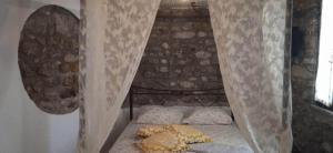 un piccolo letto in una camera con tende di Kallisto Traditional Guesthouse a Litóchoron