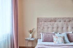 ムカチェヴォにあるCentral Two room Lux Apartmentsのベッドルーム1室(ベッド1台、テーブル上の花瓶付)