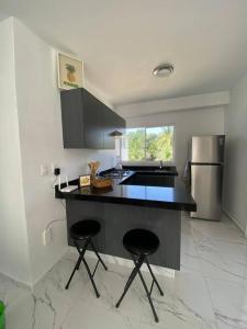 uma cozinha com um balcão preto e um frigorífico em Departamento Acapulco Diamante - 2 habitaciones em Acapulco