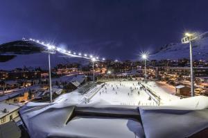 een ijsbaan in een stad 's nachts met lichten bij L'ALPE D'HUEZ Appartement 4 couchages idéalement situé in Huez