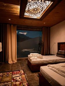 a bedroom with two beds and a window with a skylight at Full moon camp in Disah