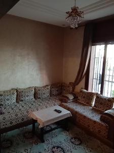 a living room with a couch and a table at Appartement Kennedy in Safi