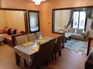 a dining room with a table and chairs and a living room at Appartement Kennedy in Safi