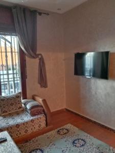 a living room with a couch and a flat screen tv at Appartement Kennedy in Safi