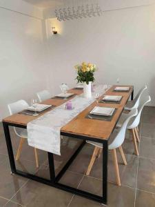 tavolo da pranzo con sedie bianche e tavolo in legno con fiori di The White House a Eldoret