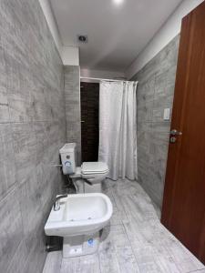a bathroom with a toilet and a sink at Depto acogedor, moderno y espacioso in Rosario