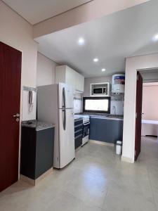 una cocina con electrodomésticos blancos y armarios azules en Depto acogedor, moderno y espacioso en Rosario