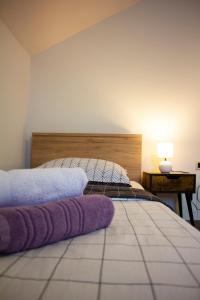 een slaapkamer met een bed met paarse handdoeken erop bij Timeless in Gospić