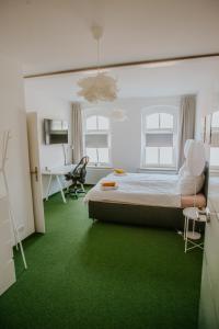 a bedroom with green carpet and a bed and a desk at traumhaftes Apartment am Dom mit großer Dachterrasse in Zwickau