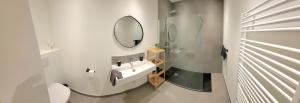 a white bathroom with a sink and a mirror at Family apartment on the ground floor with terrace - Panne A Côte in De Panne