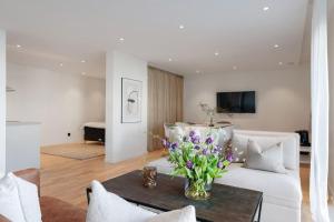 a living room with a white couch and a table with flowers at Havsnära våning in Uddevalla