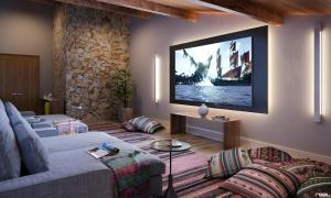 uma sala de estar com um sofá e uma televisão na parede em Wanderlust em Campos de Jordão