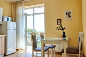 eine Küche mit einem Tisch mit Stühlen und einem Kühlschrank in der Unterkunft Central Two room Lux Apartments in Mukatschewo