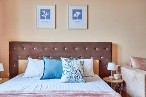 Schlafzimmer mit einem Bett mit blauen und weißen Kissen in der Unterkunft Central Two room Lux Apartments in Mukatschewo