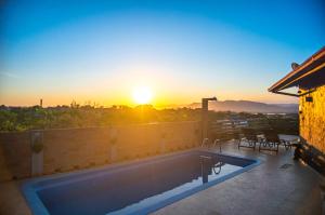 a swimming pool on the roof of a house with the sunset at Bangalôs do Rosa-Praia do Rosa in Imbituba