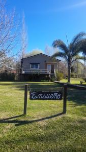 a sign in the grass in front of a house at Ensueño casa de isla in Tigre