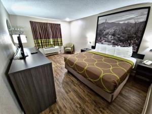 ein Hotelzimmer mit einem Bett und einem Schreibtisch in der Unterkunft Super 8 by Wyndham Goodyear/Phoenix Area in Goodyear