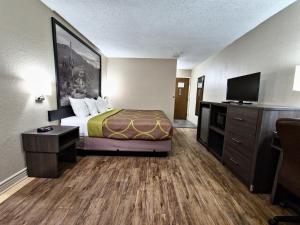 a hotel room with a bed and a flat screen tv at Super 8 by Wyndham Goodyear/Phoenix Area in Goodyear