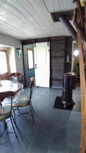 a living room with a table and chairs and a door at Domaine des Terres du Milieu / Gîte de cul de sac in Châteldon